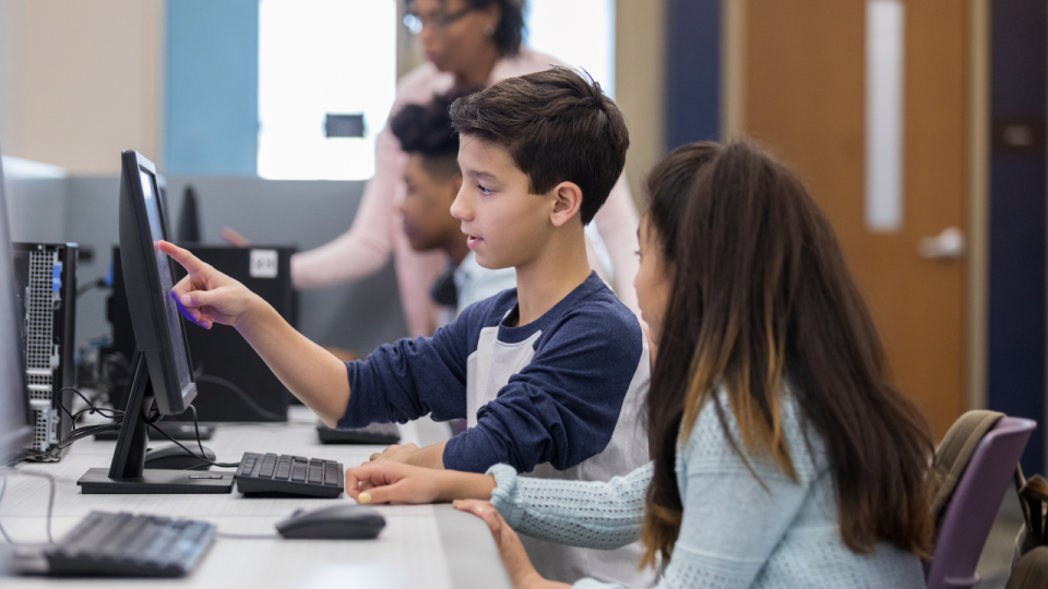 Girl and boy working together at a computer in a computer lab