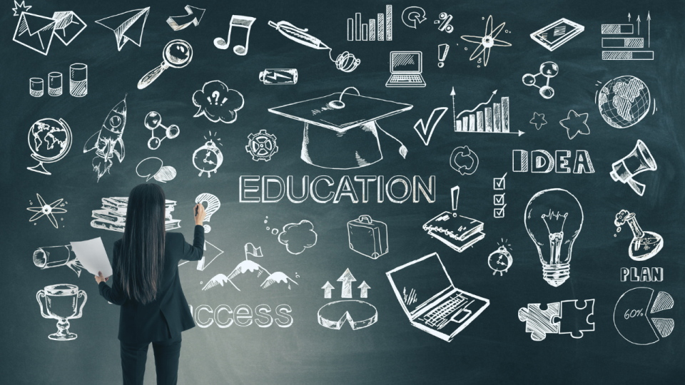 Woman writing on a chalkboard with the word "Education" in the center and various chalk drawings of STEM concepts