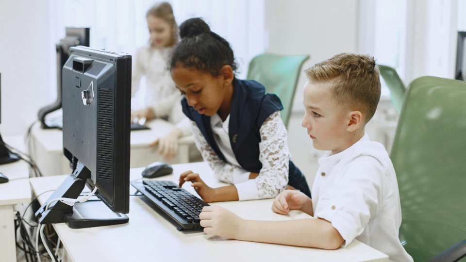 Girl and boy working together at a computer in a computer lab