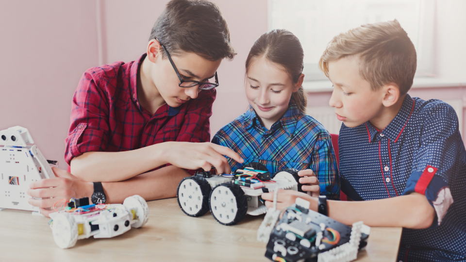 Two boys and a girl working on a robot